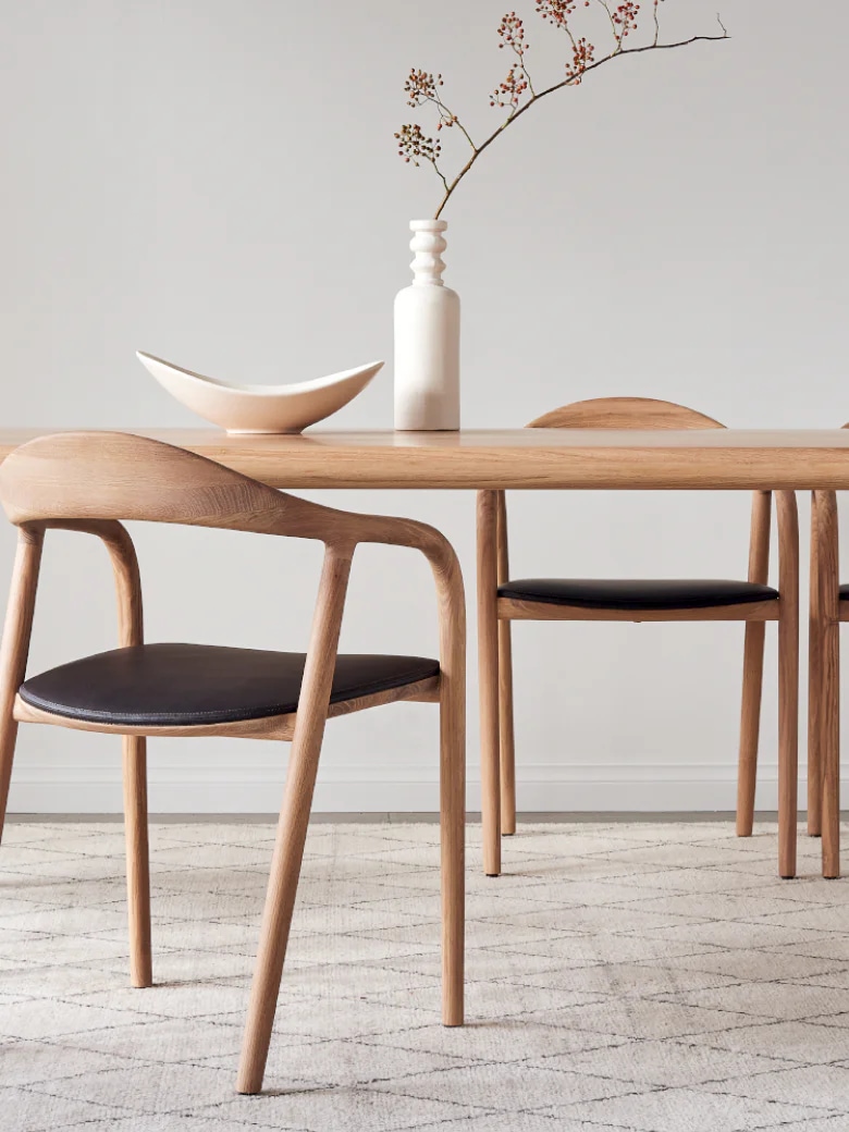 우드 소재의 Neva Chair와 우드 다이닝 테이블이 함께 배치된 이미지 