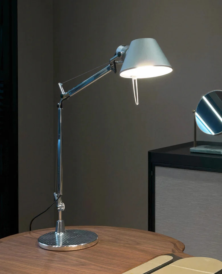 메탈 쉐이드와 관절형 암 구조의 Tolomeo Mini Table 조명이 테이블 위에 놓인 이미지 